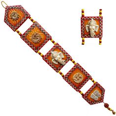 an elephant head is hanging on a red and yellow bracelet with two matching earring clips