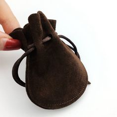 a hand is holding a small brown bag