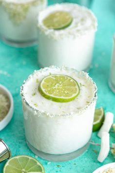 two margaritas with lime slices on the rim and salt in the middle, surrounded by other drinks