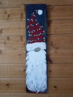 a painting of a santa clause on a wood paneled wall with beads around his beard