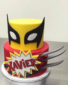 a birthday cake decorated to look like a superhero mask with the word's name on it