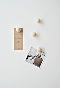 an open photo book with three wooden balls on it and a piece of paper next to it