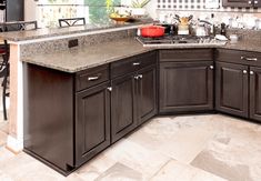 a kitchen with brown cabinets and marble counter tops