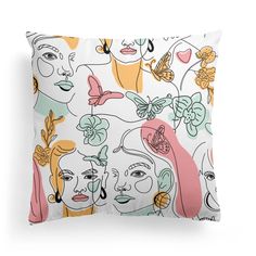 a white pillow with colorful faces and butterflies on the front, against a white background