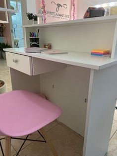 a white desk with a pink chair underneath it