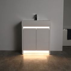 a white sink sitting next to a wall mounted faucet with lights on it