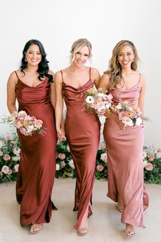 three bridesmaids in red dresses standing next to each other with their bouquets