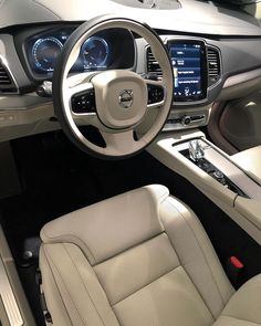 the interior of a car with beige leather seats and dashboards, including an electronic display