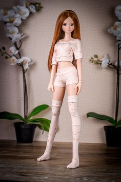 a doll with red hair and white stockings is standing in front of some potted plants