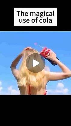 a woman is drying her hair in front of the sky with an ad for coca cola