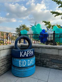 a blue tire sitting on top of a sidewalk next to a sign that says kappa bid day