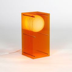 an orange lamp sitting on top of a white table