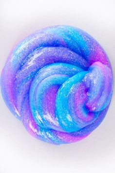 a blue, purple and pink swirled dough on a white surface