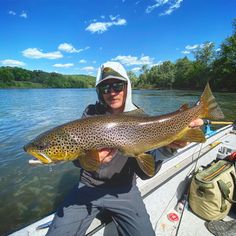 a man on a boat holding a large fish