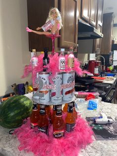 there is a cake made to look like a barbie doll on top of some bottles