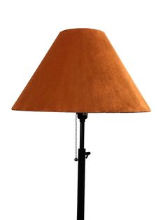 a lamp that is on top of a black stand with a brown shade over it