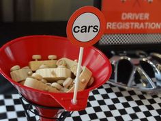 a red bowl filled with lots of food on top of a checkered table