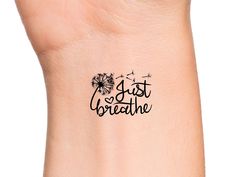 a wrist tattoo with the words just breathe written in black ink and dandelions