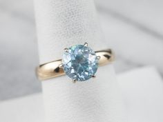 This simple but stylish ring has a great profile, and is the perfect frame for the luscious blue zircon that we've set at the center! The ring itself is a two tone gold design and has an airy, yet strong undercarriage. Particularly nice is the way that this frame shows off the entire stone, allowing lots of light to flow through! Metal: 18K White Gold, 14K Yellow Gold Gem: Blue Zircon 3.90 Carats Gem Measurements: 8.3 mm, Round Ring Size: 8.25 Marks: "TREASURELAND 14K" Stamped on the inside band Light Blue Brilliant Cut Fine Jewelry Ring, Fine Jewelry Light Blue Sapphire Ring With Center Stone, Classic Light Blue Rings For Anniversary, Fine Jewelry Light Blue Ring With Prong Setting, Light Blue Ring With Prong Setting, Light Blue Fine Jewelry Ring With Prong Setting, Light Blue Topaz Ring With Prong Setting, Light Blue Sapphire Ring With Center Stone, Solitaire Aquamarine Ring Round Cut