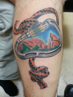 a man's leg with a tattoo on it that has an image of a snake in a shoe