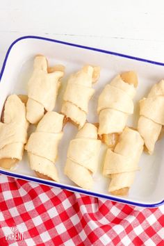 several pieces of food in a white dish on a red and white checkered table cloth