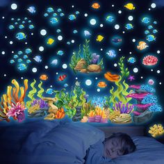 a child is sleeping in bed under the ocean wall decals