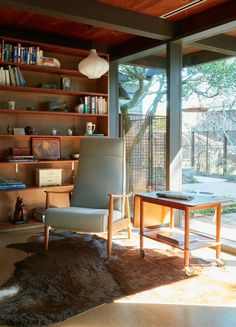 a living room filled with furniture and a book shelf next to a sliding glass door