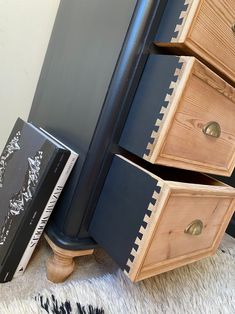 a black dresser with three drawers and two books