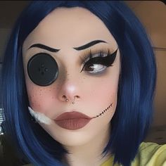 a woman with blue hair and makeup has her nose painted like a creepy clown face