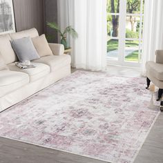 a living room with a couch, chair and rug on the floor in front of a sliding glass door