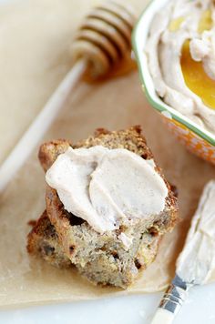 a close up of a piece of bread with cream on it and a spoon next to it