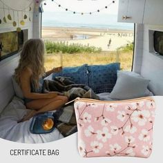 a woman sitting on a bed with a pink flowered bag in front of her