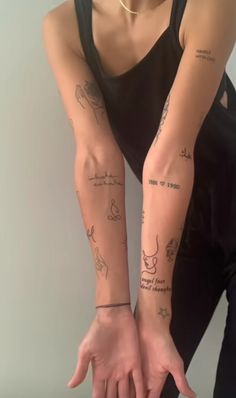 a woman with many tattoos on her arm and arms, both showing their hands to the side