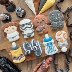 star wars cookies are arranged on a cutting board with cookie cutters and other decorations