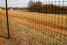 a large field behind a wire fence