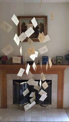 several pieces of paper are falling from the ceiling in front of a fire place with a fireplace