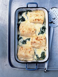 a casserole dish with spinach and cheese in it on a metal tray