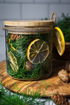 a glass jar filled with lemons and pine cones