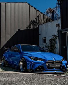 a blue sports car parked in front of a building