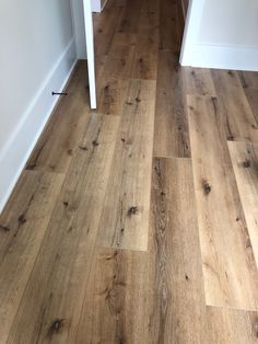 a wood floor with white walls and wooden floors in the hallway or kitchen area is shown