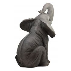 an elephant figurine sitting on the ground with its trunk up and it's eyes closed