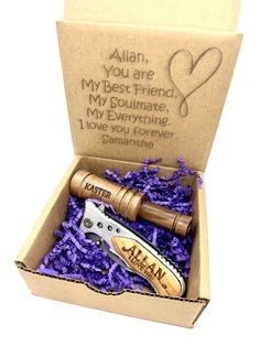 a wine bottle opener and corkscrew gift set in a box with purple shredded paper