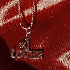 a silver necklace with the word lover written on it and a heart in the middle