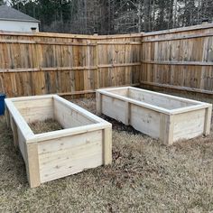 three wooden raised planters sitting in the grass