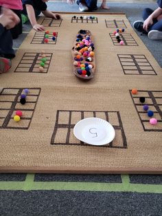 a group of children sitting around a table with a game on it