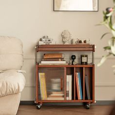 a living room with a chair and book shelf on wheels in front of the couch