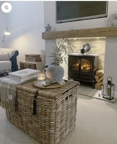 a living room with a fire place and wicker basket on the floor next to it