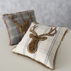 two decorative pillows with deer heads on them