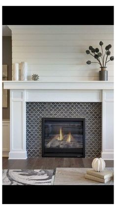 a living room with a fire place in the center and white furniture on the other side