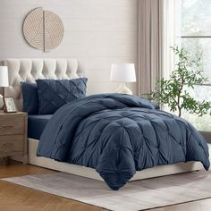 a bed with blue comforter and pillows in a room